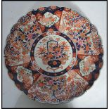 A 19th century Japanese Imari charger of large form having a scalloped edge. Hand painted in the