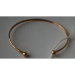 A hallmarked 9ct gold bangle with ball finials. Hallmarked Birmingham. Weight 2.5g.