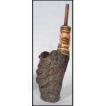 A 19th century African smoking pipe. The bowl carved in the form of a grotesque figure. Measures