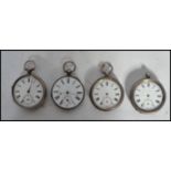A group of four vintage early 20th century silver pocket watches all having white enamel faces