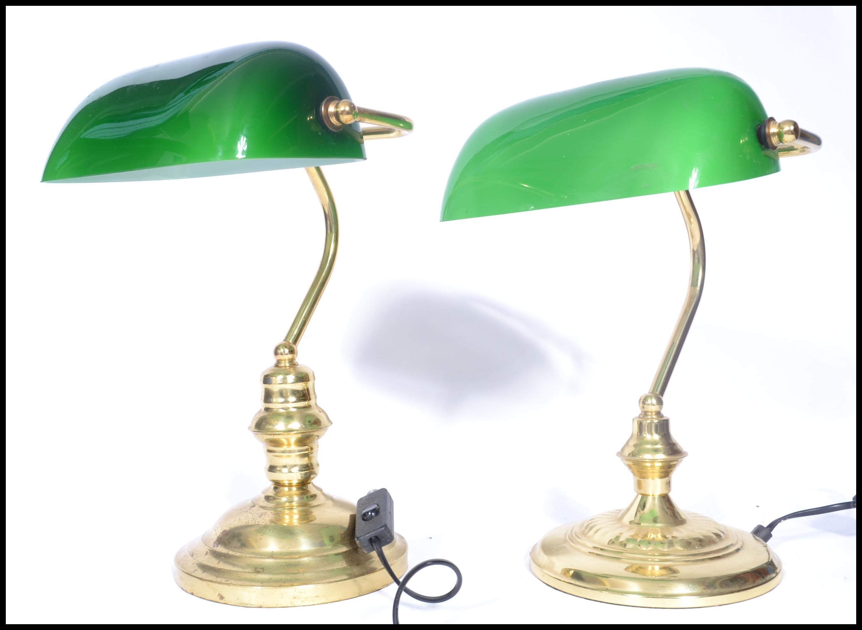 A near pair of vintage style 20th century brass bankers lamps raised on circular bases with arched