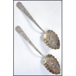 A pair of 19th century Chinese silver serving spoons having an engraved design with embossed dragons