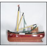 A vintage 20th century scratch built model of a fishing trawler boat being hand painted with