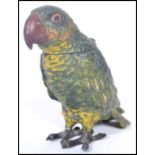 An early 20th century cold painted metal novelty inkwell in the form of a parrot having hinged lid