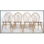 A set of 4 1970's retro hoop back beech and elm wood Ercol light dining chairs. Raised on turned