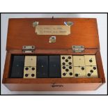 A cased set of vintage 20th century ebony and bone dominoes within the original box with plaque to
