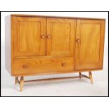 A vintage 20th century retro beech and elm Ercol sideboard raised on tapering legs. Having a