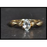 A hallmarked 9ct gold ring having a central  white stone with twist shoulders. Weighs 1.8 grams size