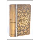 A 19th century Victorian brass snuff box in the form of a book having an engraved leaf design with