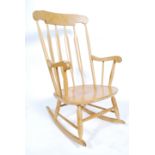 A 20th Century elm and beech Windsor rocking chair with a concave top rail above a rail back over