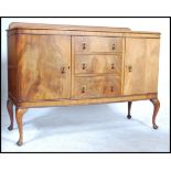 An early 20th century Edwardian walnut sideboard buffet having a central bank of drawers flanked