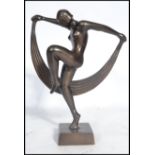 A 20th century Art Deco statue of a nude lady flapper girl dancing with cloth raised on a square