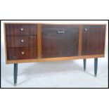 A  retro 20th century Danish influence teak wood sideboard raised on tapering legs with a series