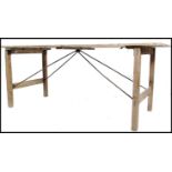 A vintage mid 20th century NAAFI dispersal folding table, plank top with square legs supported