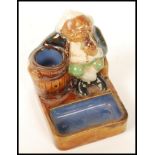 A Royal Doulton Lambeth, Harry Simeon, Gnome Smoking Match Holder, 8656 having a seated Gnome