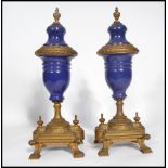 A pair of 19th century French clock garnitures in the form of lidded urns having ormolu stepped