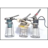 A group of three vintage 20th century retro industrial steel wire caged work lights, each with