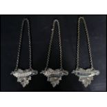 A group of three vintage 20th century silver white metal decanter labels. The labels of leaf form on