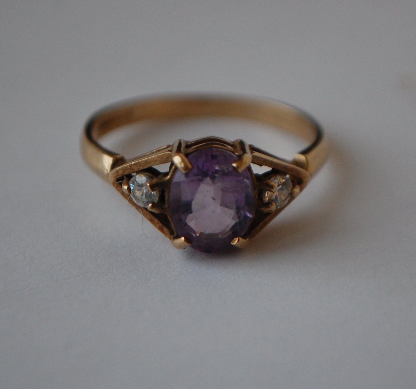 A hallmarked 9ct gold three stone ring set with a central oval cut purple stone flanked by two white - Image 3 of 3