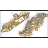 Two 19th century Victorian brass doorstops of scrolled form and the other having a finial to top