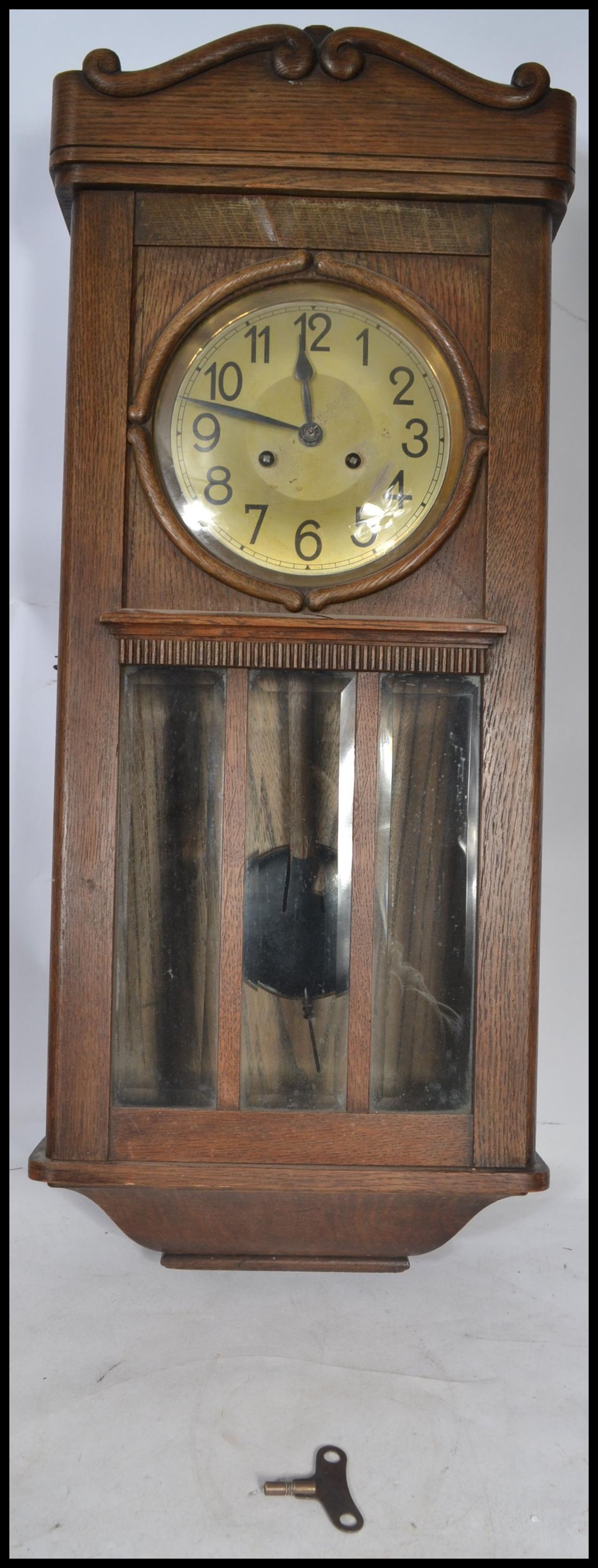 A vintage early 20th century oak wall clock having a silvered dial with Arabic numeral chapter