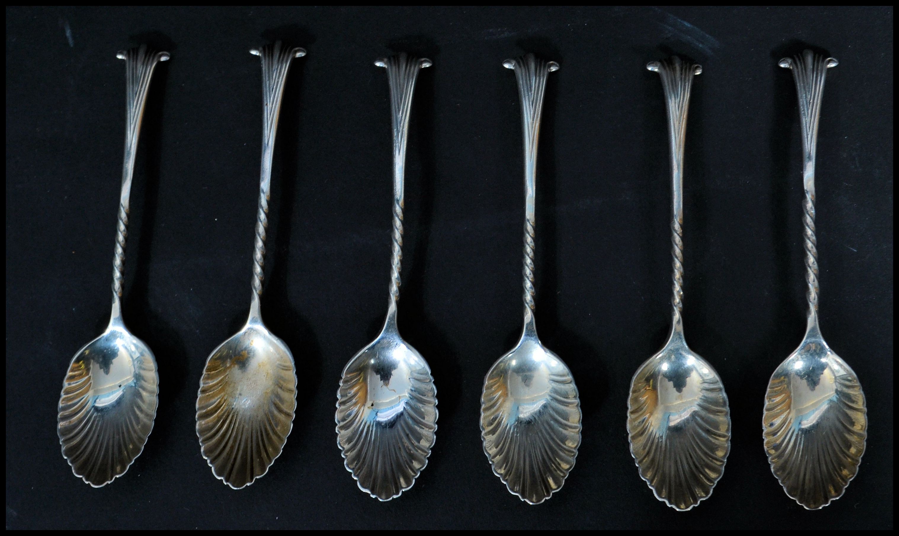 A set of six silver hallmarked shell tea spoons. The bowls in the form of shells with twist stems