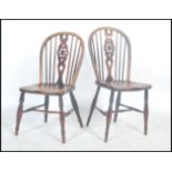 A pair of 19th century English Windsor antique elm star back and spindle dining chairs raised on