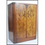 An early 20th century Art Deco walnut linen press tallboy cupboard having an inset plinth  base with
