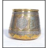 A 19th century Middle Eastern Islamic brass prayer bowl overlaid with silver and copper having