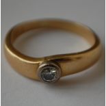 A hallmarked 18ct gold and diamond solitaire ring having a bezel set round cut diamond. Diamond