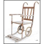 A 19th century Victorian oak invalid chair having wire wheels with shaped supports and handles.