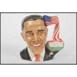 A Royal Doulton character jug depicting President Obama D7300, handle modelled as the white house