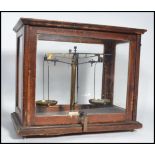 A cased set of early 20th century scientific scales with glass oak case having inset scales.