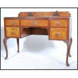 An early 20th century walnut Queen Anne revival writing desk having a series of drawers with central