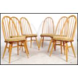 A set of 6 20th century Ercol beech and elm quaker pattern high back dining chairs. Raised on turned