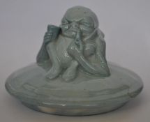 A Royal Doulton Noke blue colourway pot lid having a grotesque figure of a smoking gnome to top.