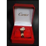 A boxed 20th century Cartier 18ct gold wrist watch set to a stainless steel bracelet. The circular