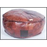 A vintage mid century leather footstool pouffe of barrel form with patchwork leather upholstery, all