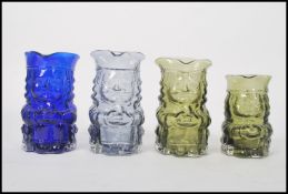 A group of four Whirefriars studio art coloured pressed glass Toby Jugs in green blue and smokey