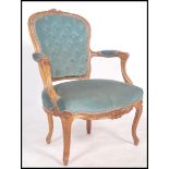 A 20th century French fauteuil armchair made from carved walnut and upholstered in a green fabric