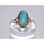 A 14ct gold and blue stone ring being set with an oval cut blue stone cabochon - possibly jade.