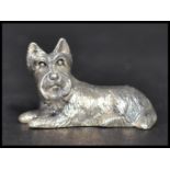 A sterling silver cast figurine of a dog in a seated position. Weighs 13 grams.
