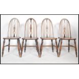 A set of four 19th century elm hoop back dining chairs raised on turned legs with H stretchers.