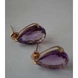 A pair of 9ct gold and amethyst earrings having large faceted pear cut amethyst stones and post