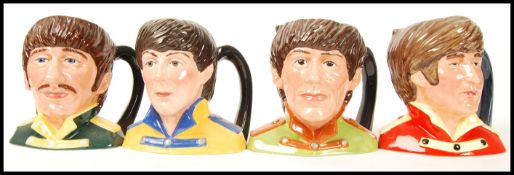 A set of four Royal Doulton character jugs of the Beatles, George Harrison D6727, Ringo Starr D6726,