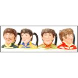 A set of four Royal Doulton character jugs of the Beatles, George Harrison D6727, Ringo Starr D6726,