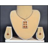 A sterling silver 925 necklace and earring demi-parure set having amber cabochon earrings. The