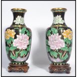 A pair of 20th century Chinese Cloisonne vases having black grounds raised on socle plinth bases.