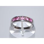 A hallmarked 9ct white gold ring having 5 channel set pink stones (tests indicate sapphire)