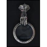 A sterling silver necklace magnifying glass pendant in the form of a mirror and hand having inset
